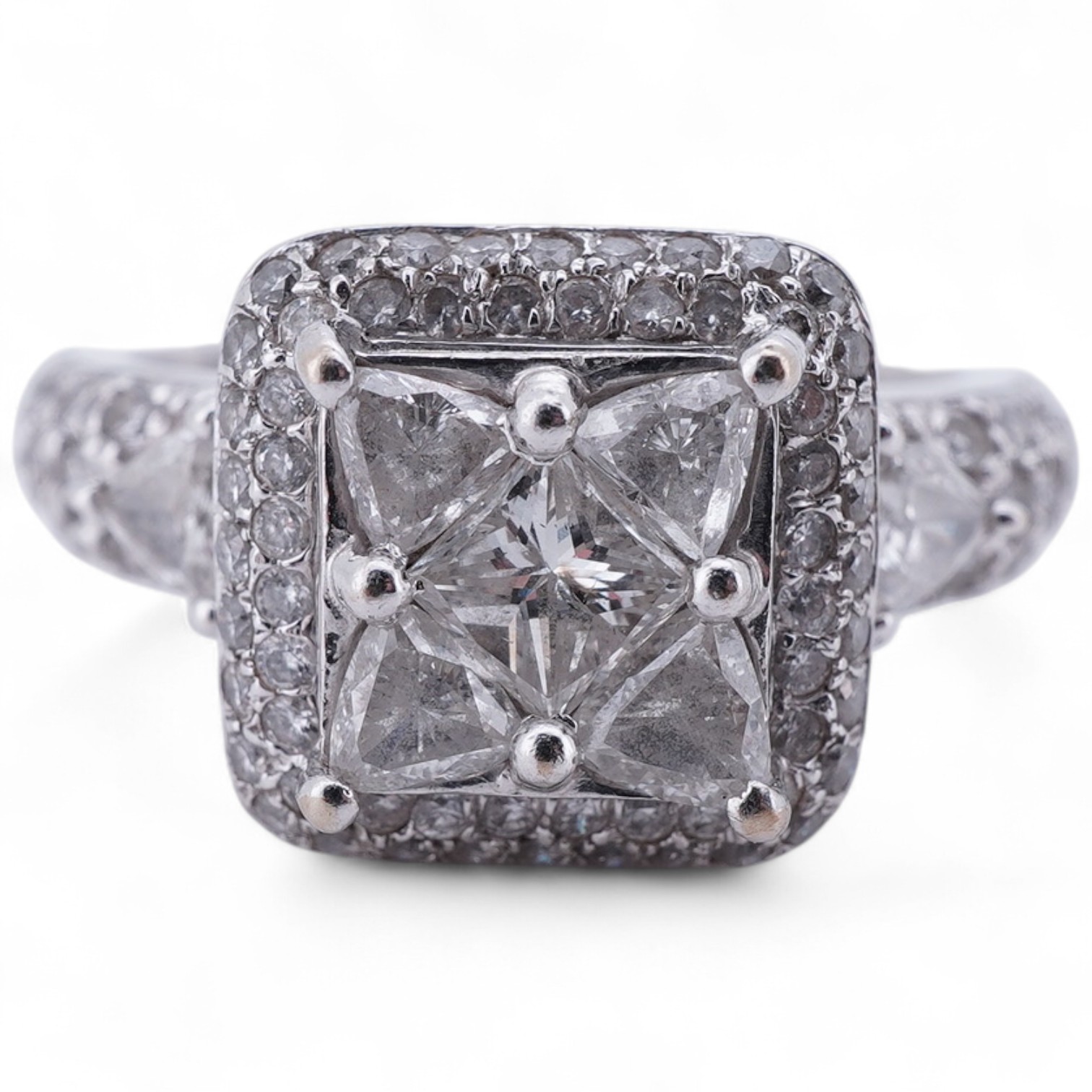 A diamond ring, centring on a tessellated arrangement of princess-cut and triangular diamonds totalling approximately 0.50 carats, to a border and band pavé-set with brilliant-cut diamonds, the shoulders accented with ad